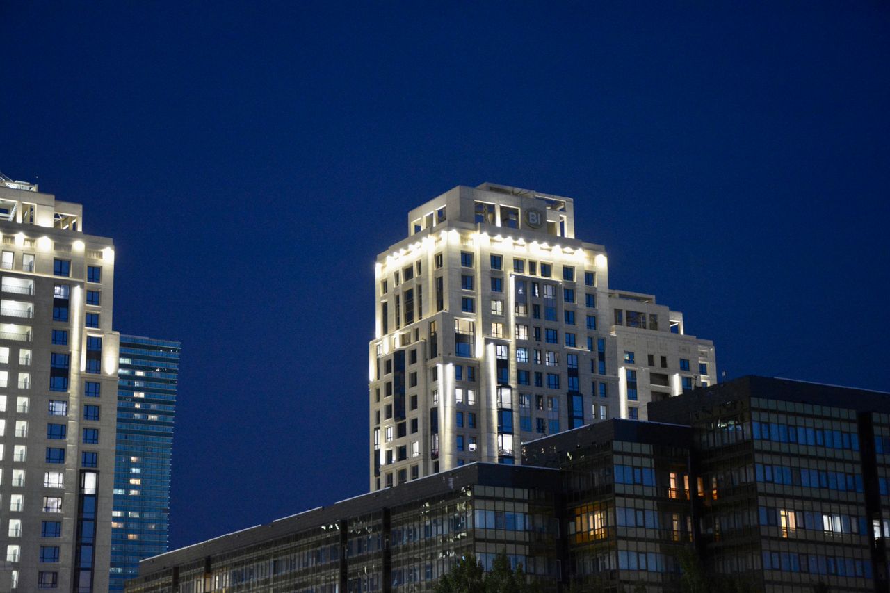 A luxury apartment tower lit up at night